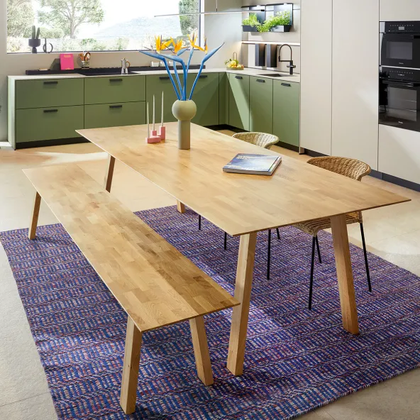 Gemütliche Küche mit Esstisch und grünen Schränken